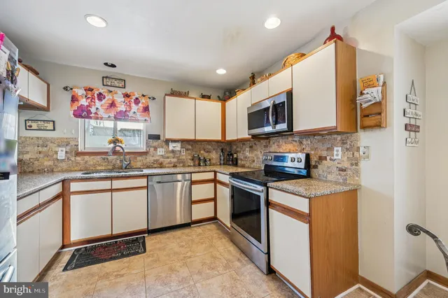 a kitchen with stainless steel appliances granite countertop a refrigerator and a sink