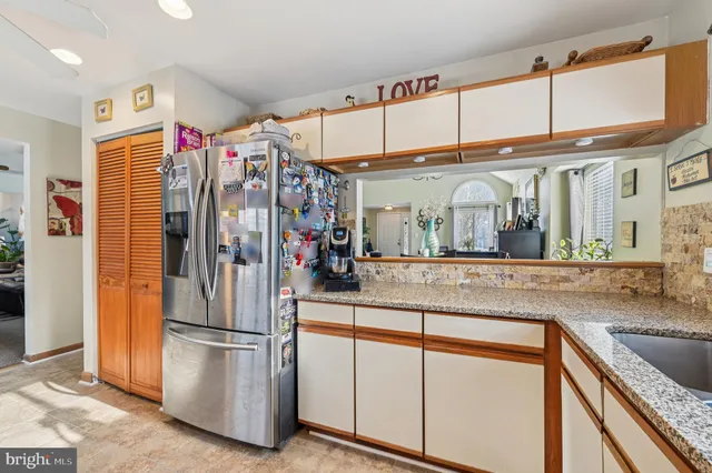 a living room with furniture a clock on wall and a window