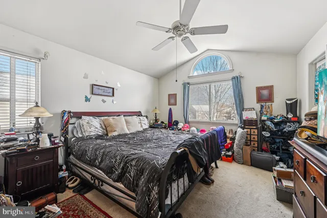 a bedroom with a bed a chandelier and dresser