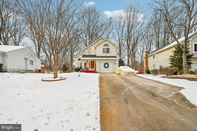a front view of a house with a yard and trees