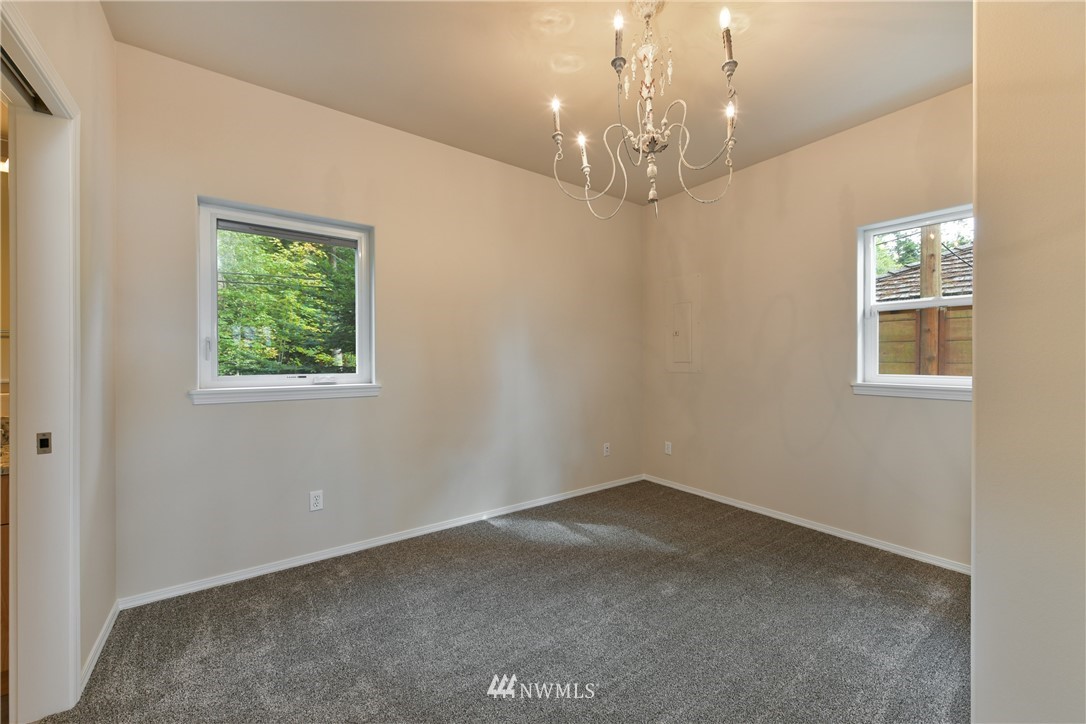 18184 Capet Zalsiluce Road La Conner, WA 98257 - Photo 15 of 25 en empty room with windows and chandelier