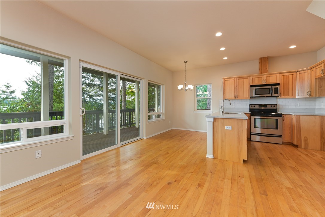 18184 Capet Zalsiluce Road La Conner, WA 98257 - Photo 8 of 25 a large kitchen with stainless steel appliances granite countertop a stove a sink a refrigerator with wooden cabinets and wooden floor