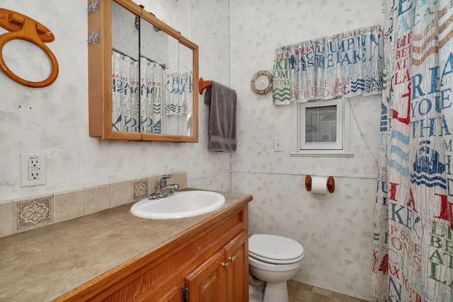a bathroom with a sink a toilet and a shower curtain