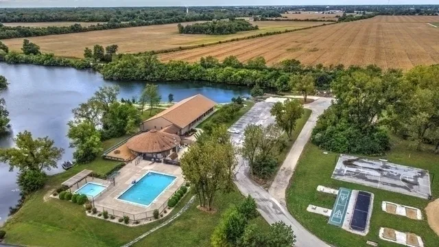 an aerial view of lake residential house with outdoor space and trees around
