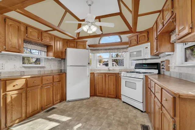 a kitchen with stainless steel appliances granite countertop a refrigerator a stove and a sink with granite countertops