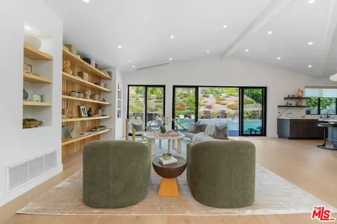 a living room with furniture large window and flat screen tv