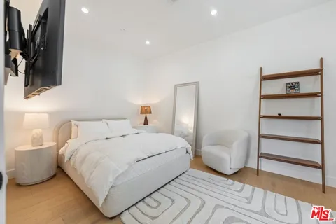 a bedroom with a bed and a flat screen tv