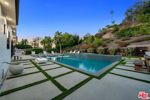 a view of a tennis ground with large trees