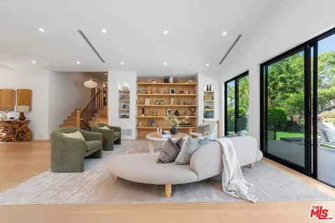 a living room with furniture and a floor to ceiling window