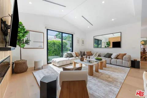 a living room with lots of furniture and a large window