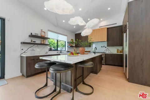 a kitchen with stainless steel appliances granite countertop a sink a stove and a refrigerator