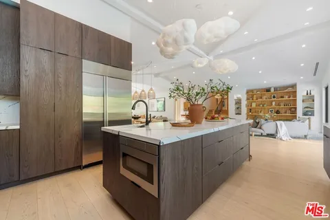 a kitchen with a stove and a view of living room