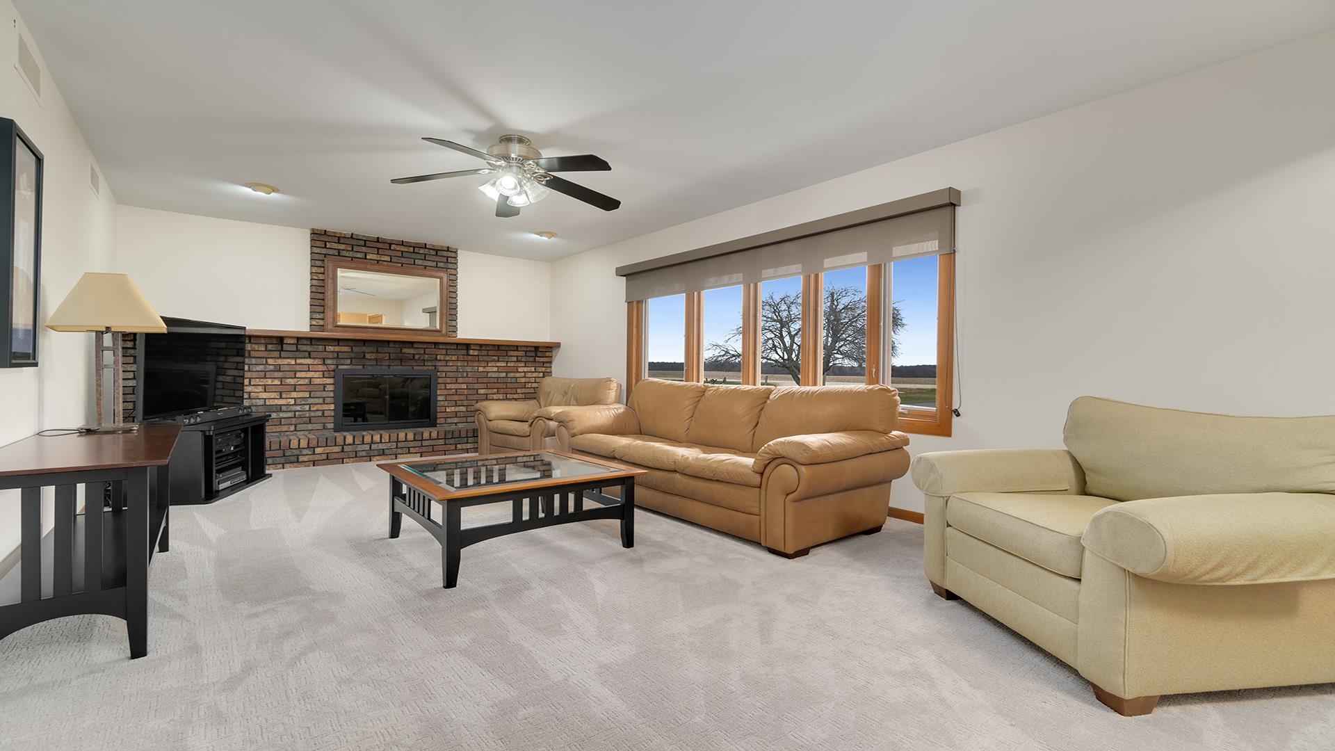 11764 North Tower Road Byron, IL 61010 - Photo 4 of 38 a living room with furniture a fireplace and a flat screen tv
