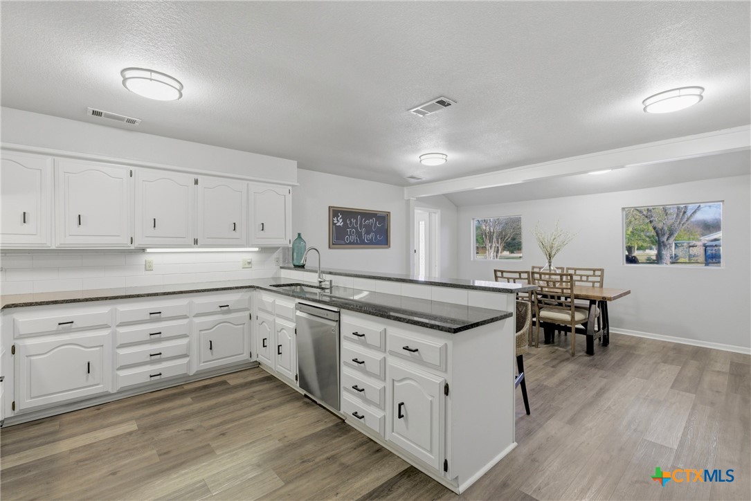 1710 Old Mill Road, Unit 12 Salado, TX 76571 - Photo 18 of 42 a kitchen with granite countertop white cabinets and white appliances