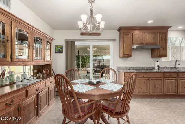 a kitchen with stainless steel appliances granite countertop a stove a sink dishwasher a dining table and chairs with wooden floor