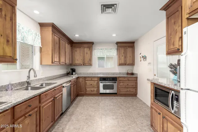 a kitchen with stainless steel appliances granite countertop a stove sink and cabinets