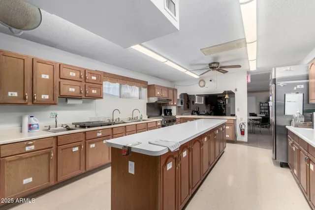 a large kitchen with stainless steel appliances a sink and a large window