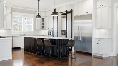 a open kitchen with stainless steel appliances granite countertop a stove top oven a refrigerator a sink and a dining table with wooden floor