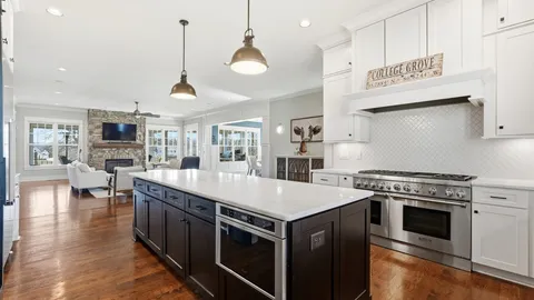 a kitchen with stainless steel appliances granite countertop a stove a sink dishwasher and a refrigerator with wooden floor