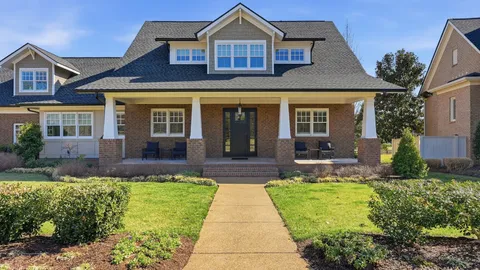 a front view of a house with a yard and potted plants