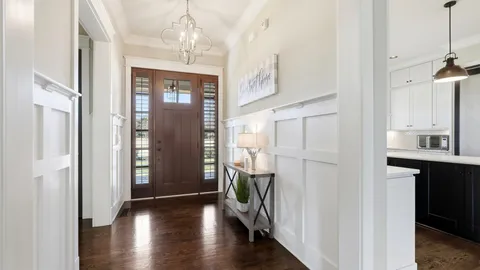 a hallway with wooden floor windows and entryway