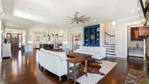 a living room with furniture a flat screen tv and kitchen view