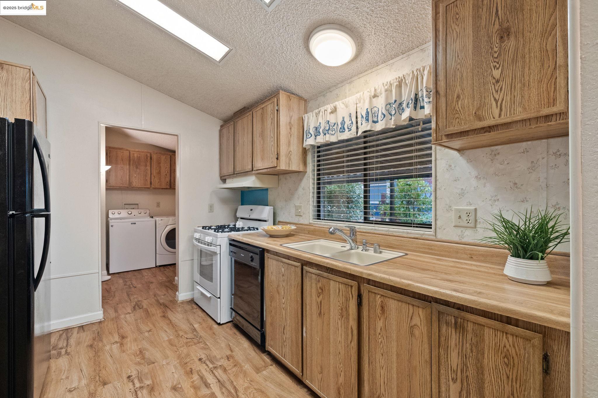 18717 Mill Villa Road, Unit 340 Jamestown, CA 95327 - Photo 8 of 21 a kitchen with stainless steel appliances granite countertop a sink a stove a refrigerator and a window