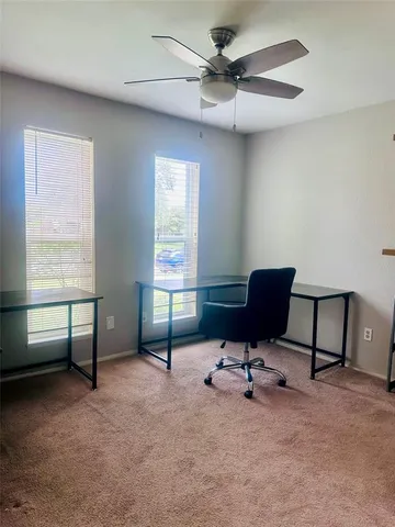 a view of a workspace with furniture and a window