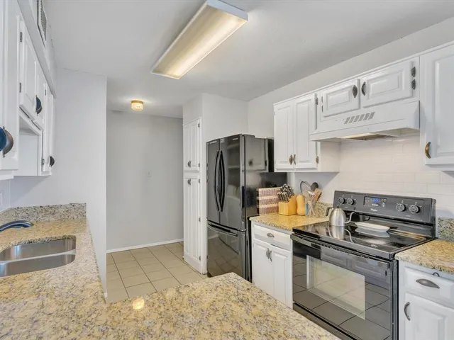 a kitchen with stainless steel appliances granite countertop a refrigerator stove and sink