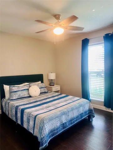 a bedroom with bed and wooden floor