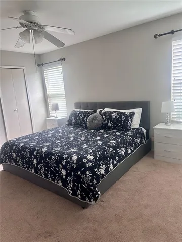 a bed sitting in a bedroom next to a window and a chandelier