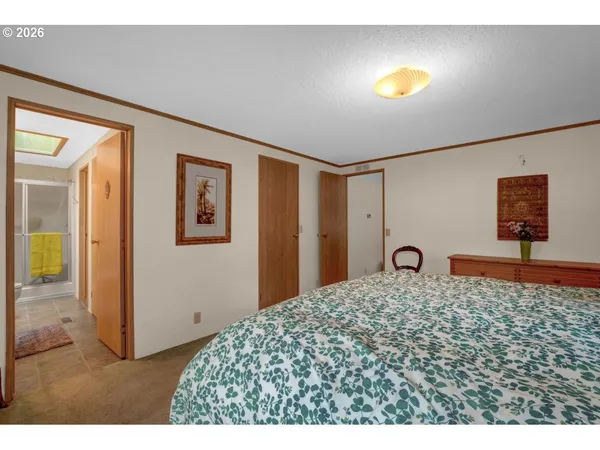 a bedroom with a large bed and large windows