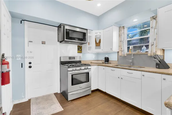 a kitchen with a sink stove and microwave