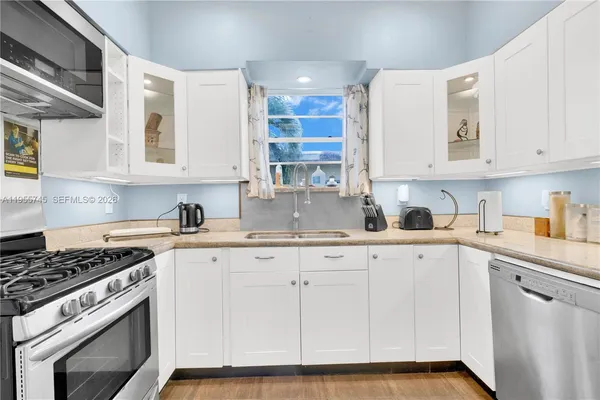 a kitchen with granite countertop white cabinets and white appliances