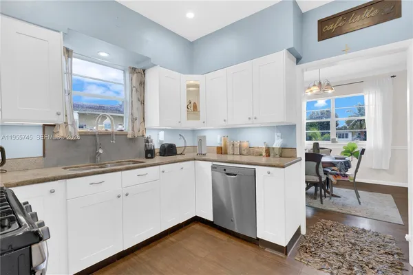 a kitchen with granite countertop white cabinets and white appliances