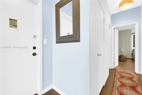 a view of a hallway with wooden floor and closet