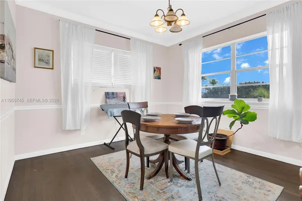 a view of a dining room with furniture a chandelier and wooden floor
