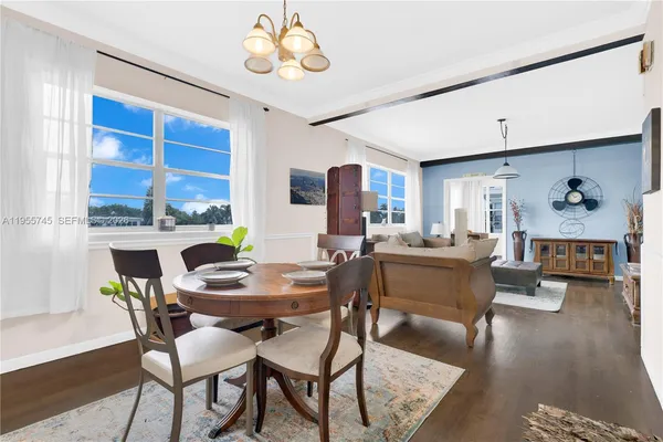 a view of a dining room with furniture wooden floor and chandelier
