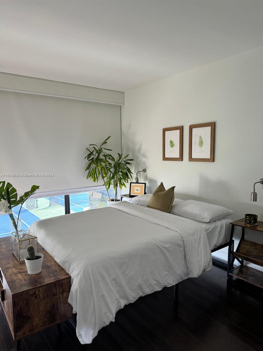 600 Northeast 36th Street, Unit 204 Miami, FL 33137 - Photo 14 of 31 a bedroom with a bed and a table in it