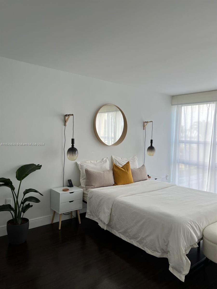 600 Northeast 36th Street, Unit 204 Miami, FL 33137 - Photo 27 of 31 a bedroom with a bed and a chandelier