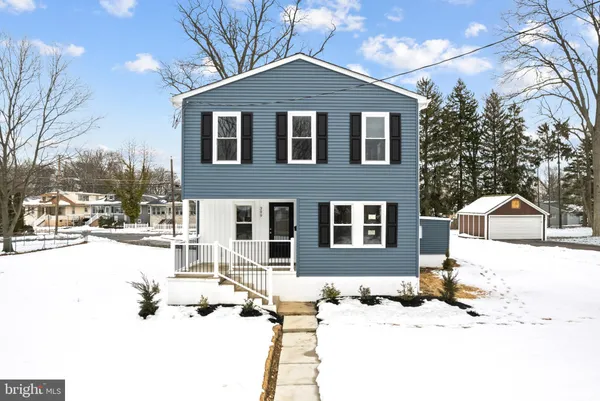 a front view of a house with a yard covered in snow
