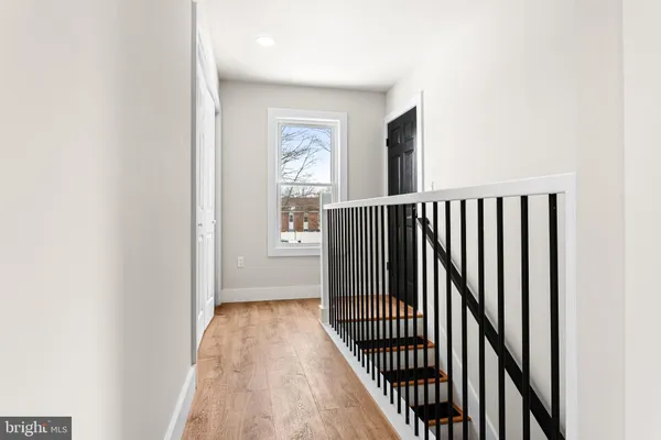 a view of a hallway with wooden floor and staircase