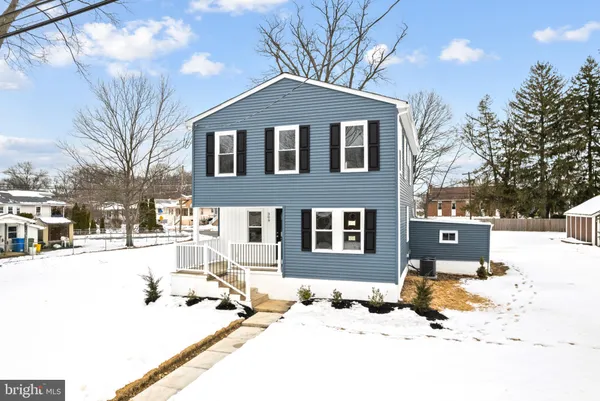 a street view of a house with snow on the road