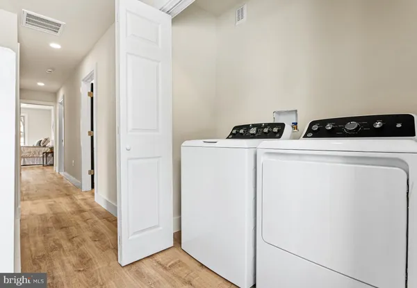 a view of washer and dryer with kitchen in the background