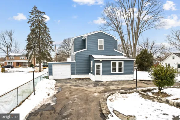 a view of a white house with a snow on the road