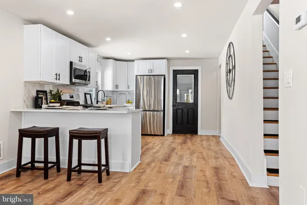 a kitchen with stainless steel appliances granite countertop a refrigerator and a stove top oven