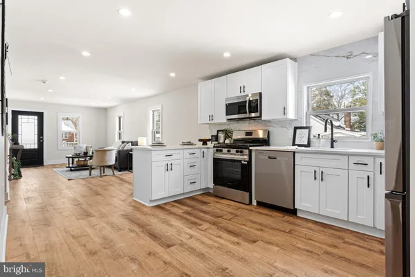 a kitchen with white cabinets and appliances
