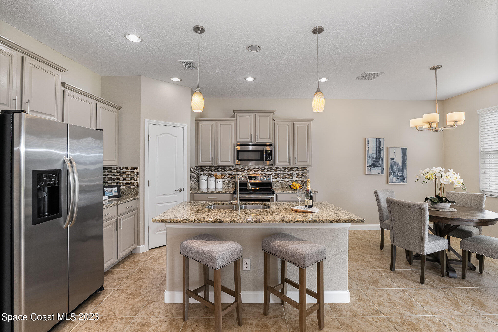 3545 Sansome Circle Melbourne, FL 32940 - Photo 12 of 27 a kitchen with refrigerator a sink and chairs
