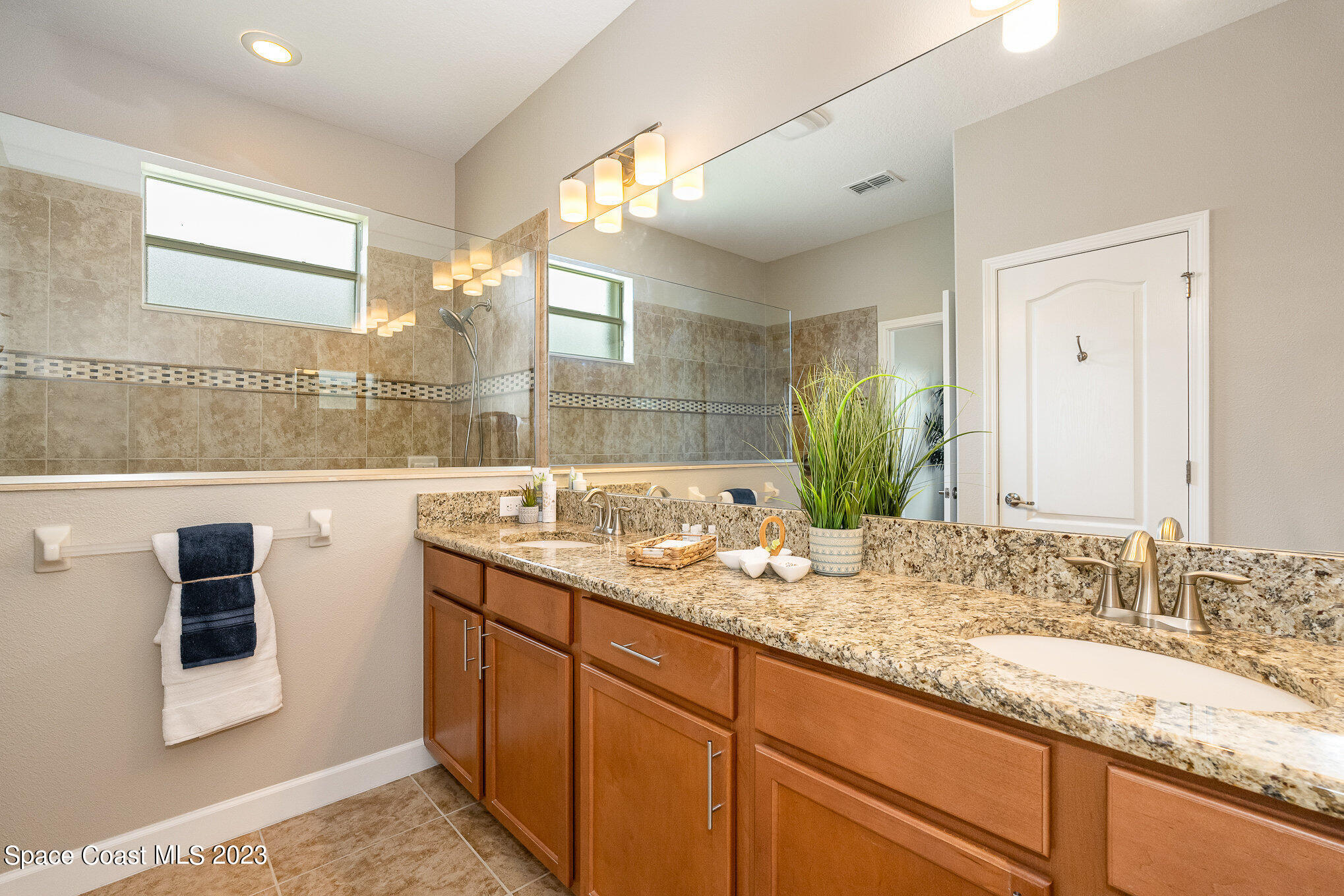 3545 Sansome Circle Melbourne, FL 32940 - Photo 18 of 27 a bathroom with a granite countertop sink and a mirror