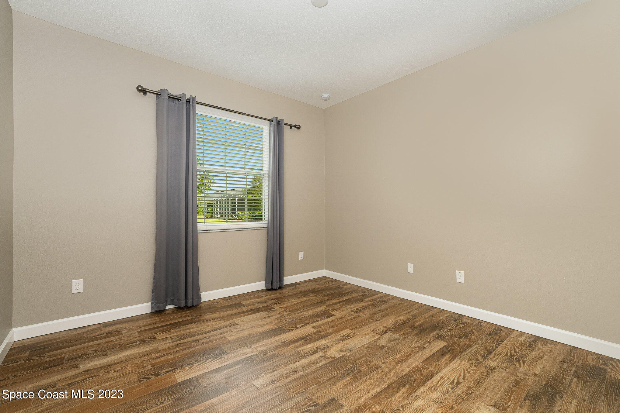 3545 Sansome Circle Melbourne, FL 32940 - Photo 19 of 27 a view of an empty room with wooden floor and a window
